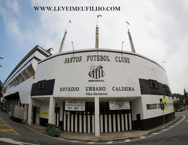 a white building with black and white stripes on the front is next to a street