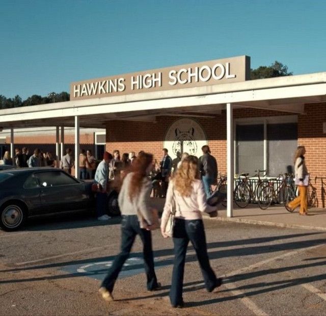 two women walking in front of a high school