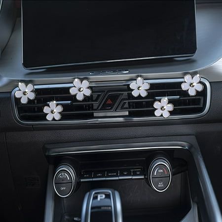 the interior of a car with flowers on it's dash board and electronic controls