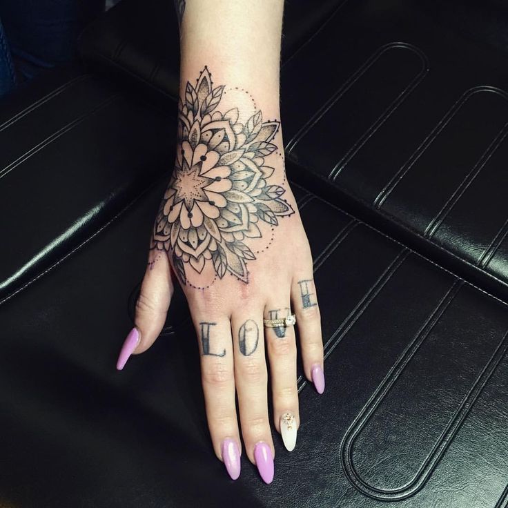 a woman's hand with a flower tattoo on it