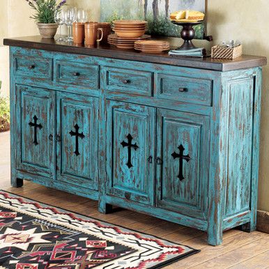 an old blue cabinet with crosses painted on the doors and drawers is in front of a rug