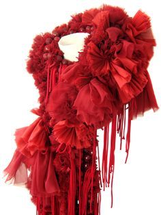 a red scarf with fringes and flowers on it