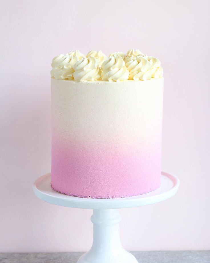 a pink and white ombreed cake sitting on top of a table