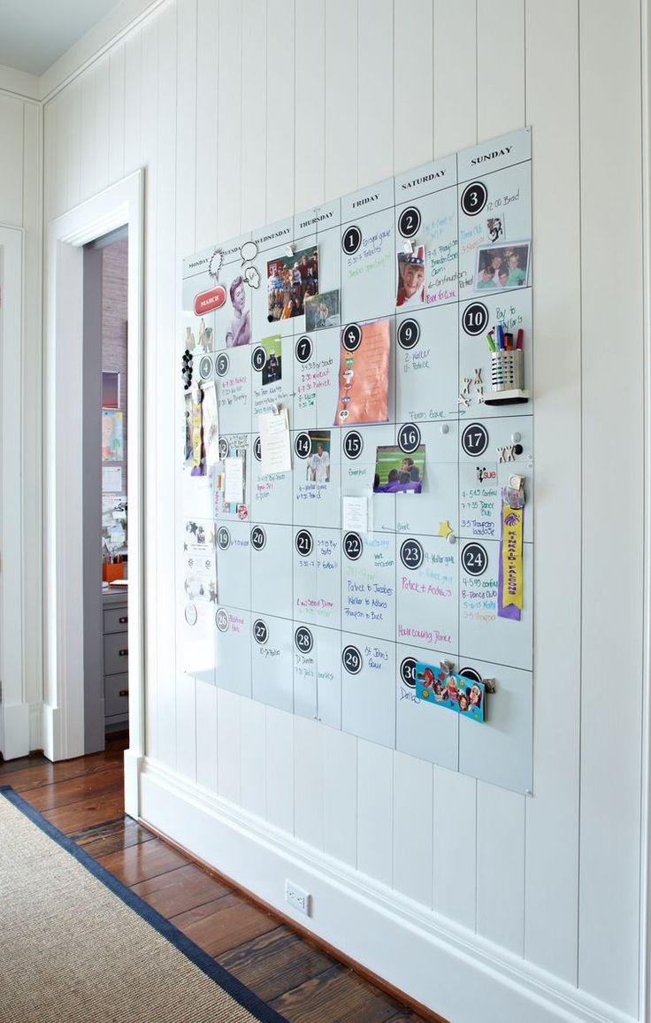 a bulletin board with pictures and magnets on it in a room next to a door