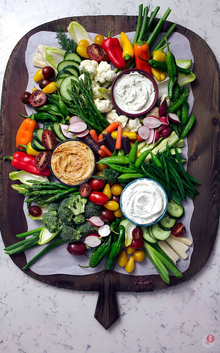 a platter filled with assorted veggies and dips