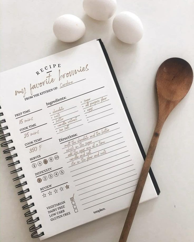 an open recipe book next to eggs and a wooden spoon