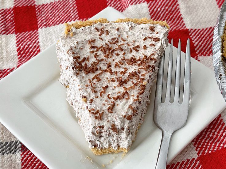 a piece of pie sitting on top of a white plate next to a silver fork