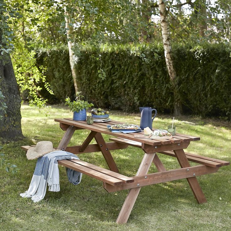 a picnic table set up in the middle of a grassy area next to a tree