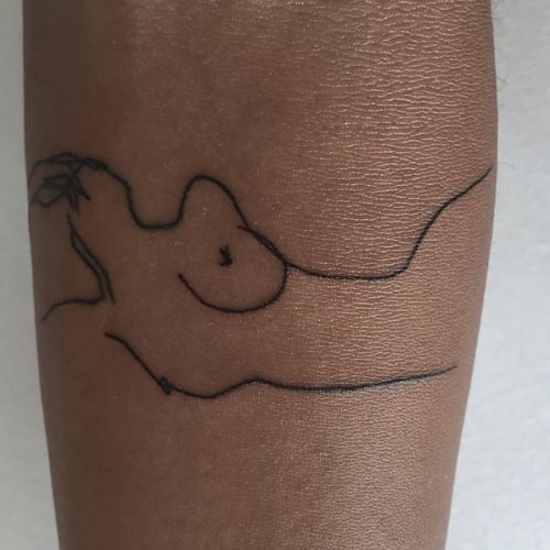 a woman's leg with a tattoo on it that has an image of a nude female