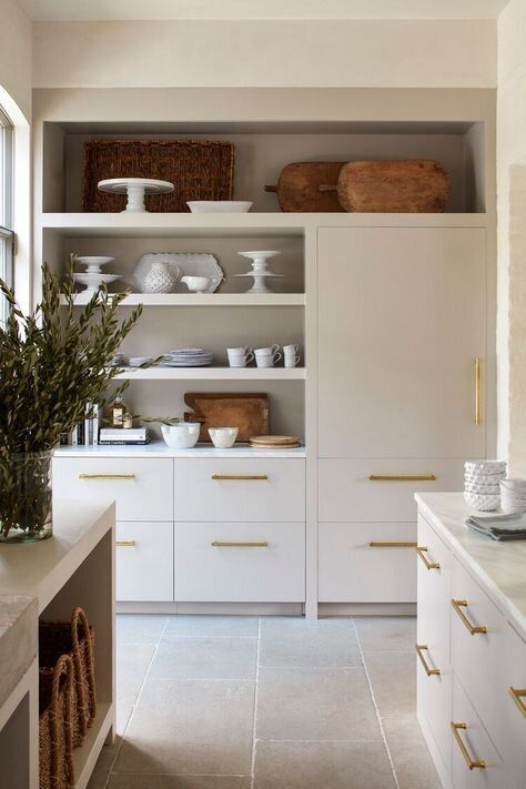 a kitchen with white cabinets and gold trim on the doors, drawers, and shelves