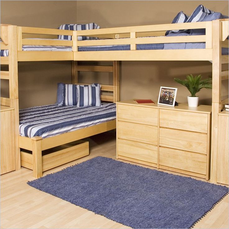 a bedroom with bunk beds and desks in the corner, on top of hard wood flooring