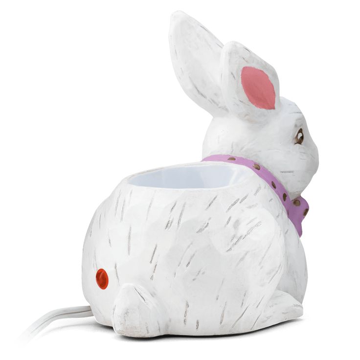 a white ceramic rabbit planter with a pink ribbon around it's neck and ears