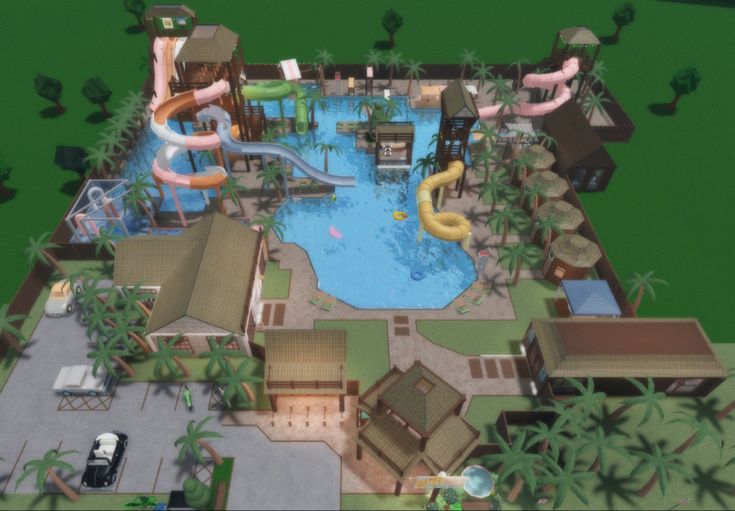 an aerial view of a resort with a swimming pool and water slide in the middle