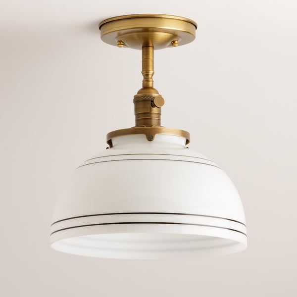 a white and gold ceiling light hanging from a ceiling fixture in a living room or bedroom