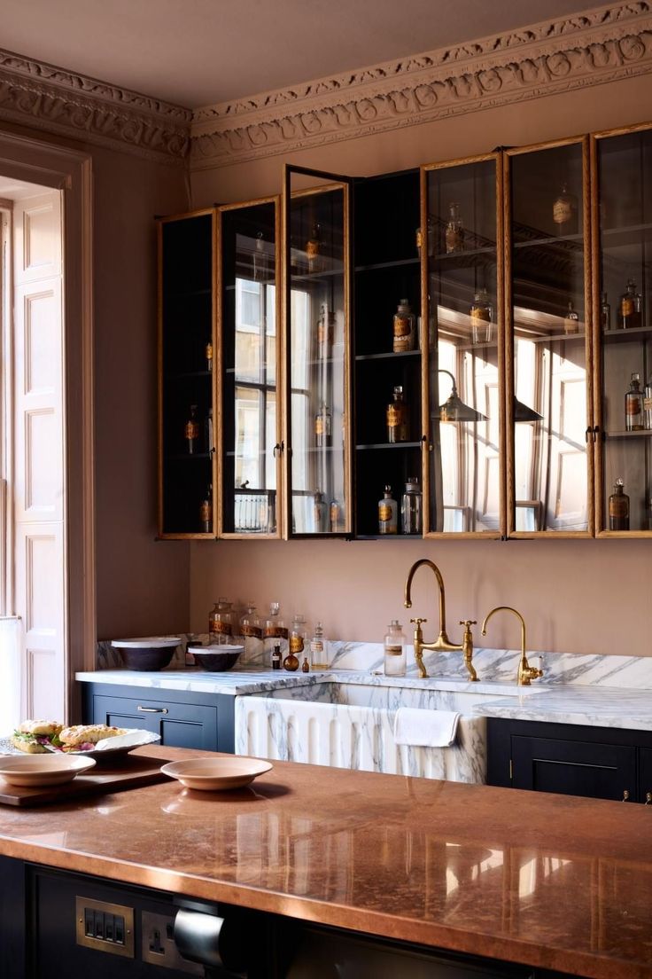 a kitchen with marble counter tops and gold trimmings on the cabinets, along with two sinks