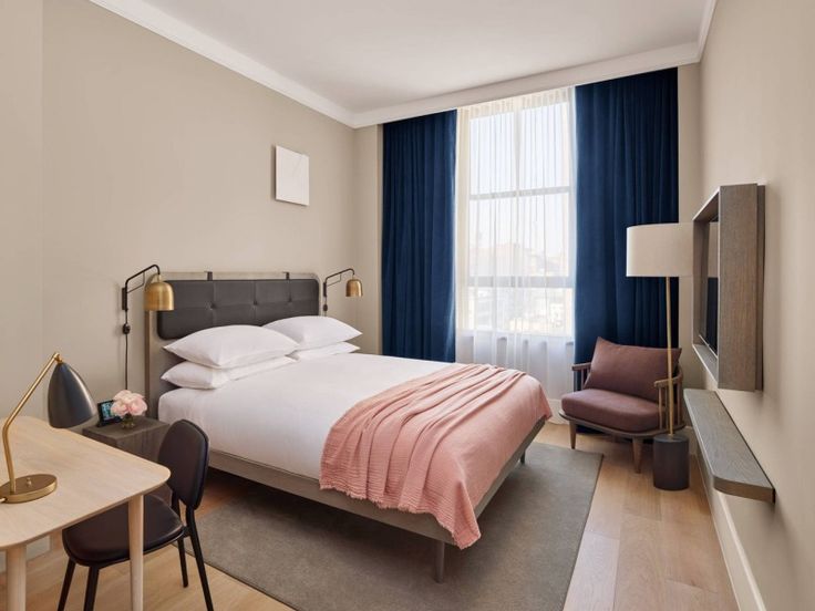 a hotel room with a bed, desk and chair