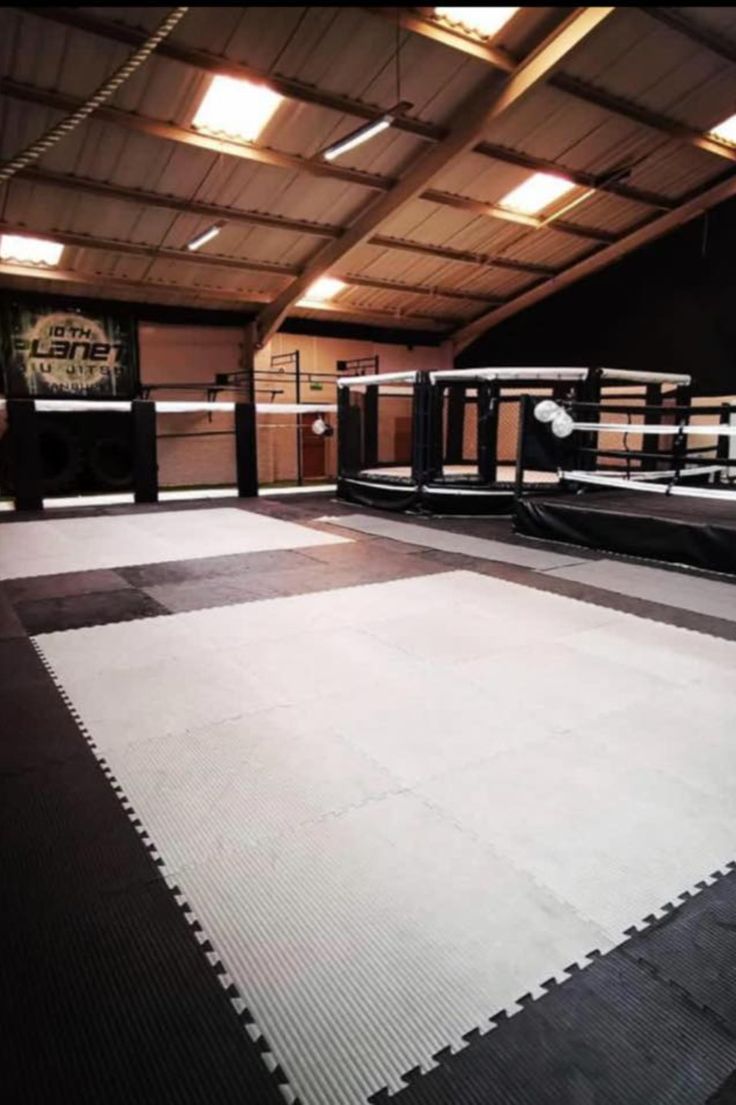 an empty boxing ring with white mats on the floor