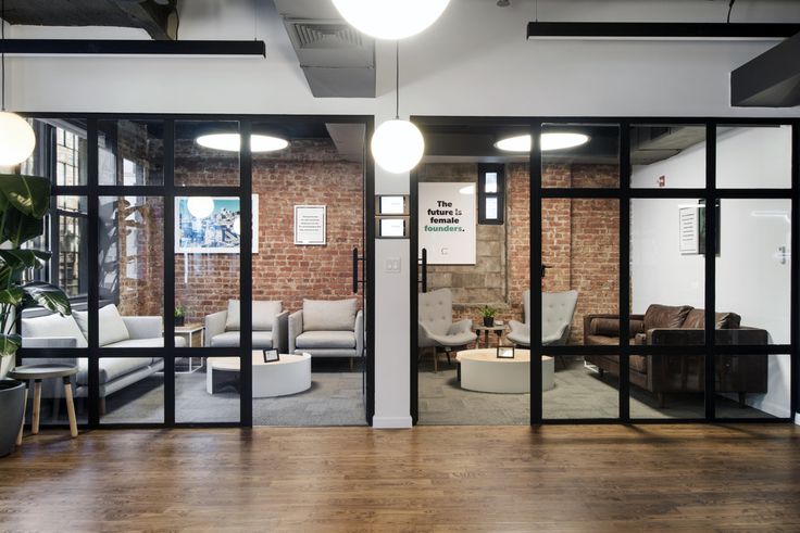 an office with glass walls and wooden floors