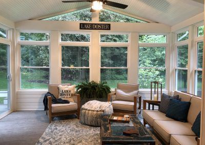 a living room filled with furniture and windows covered in white paint on the ceiling,