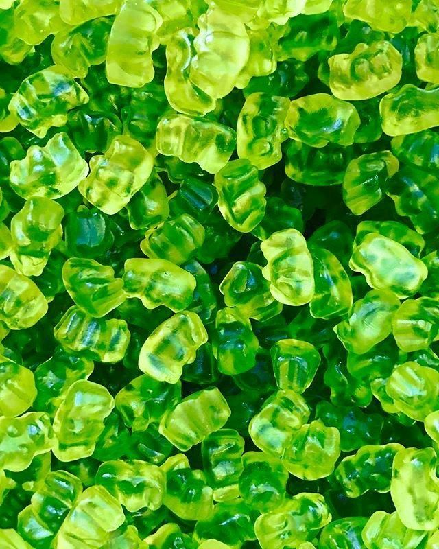 green gummy bears are in the middle of a pile