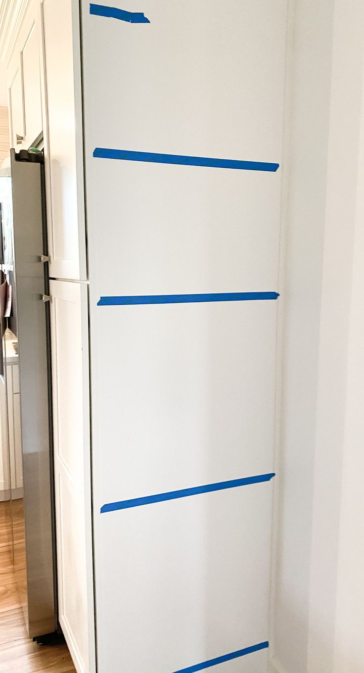 a white cabinet with blue tape on it