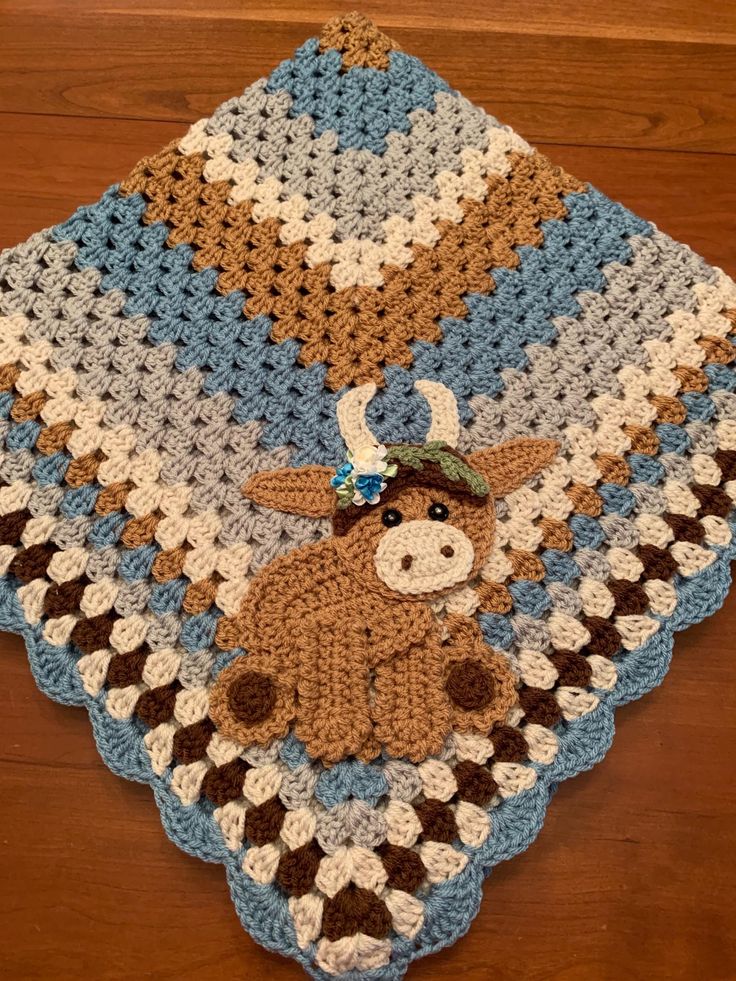 a crocheted blanket with a cow on it