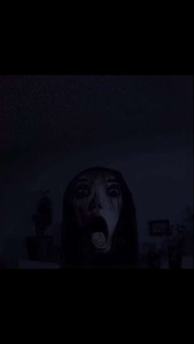 a woman with her mouth open in the dark