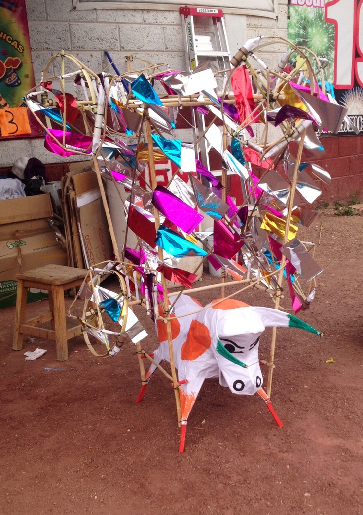 a sculpture made out of various pieces of paper on the ground next to a bench