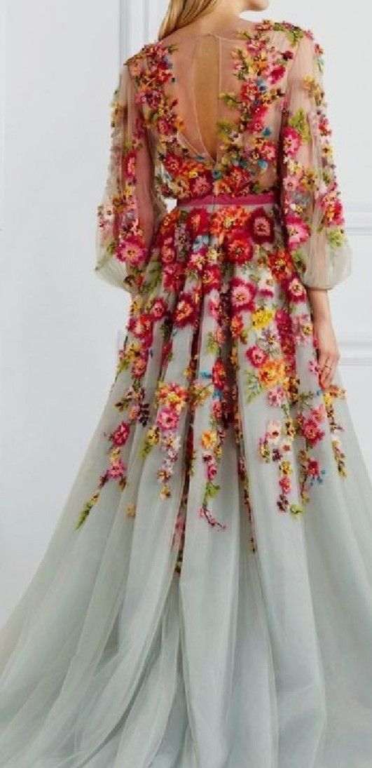 the back of a woman's dress with flowers on it, and sheer sleeves