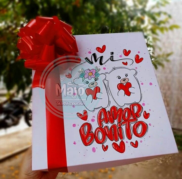 someone holding up a greeting card with a red bow