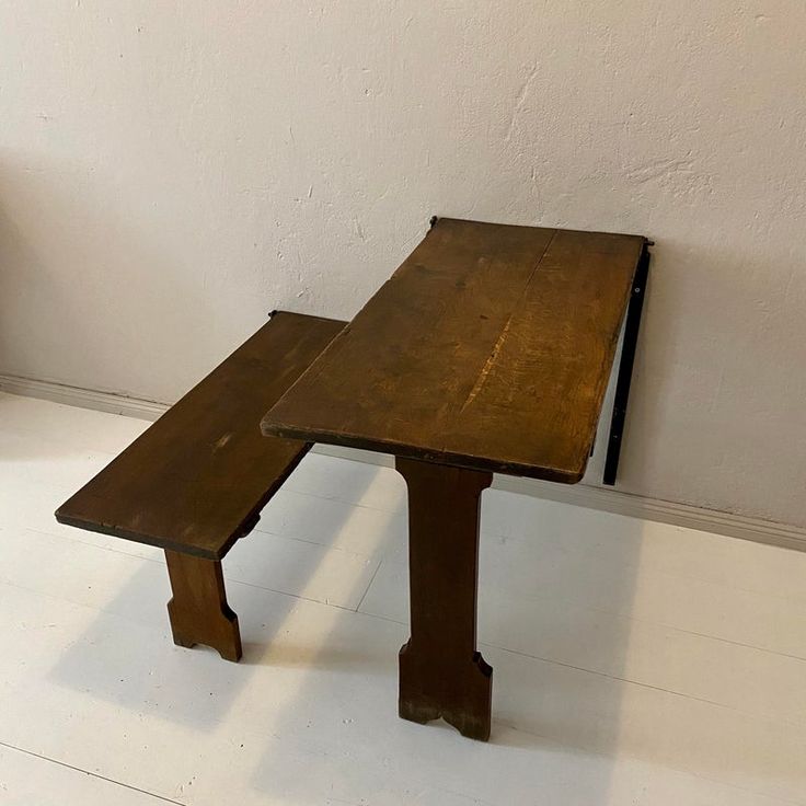 an old wooden table with two benches on the bottom and one bench at the top