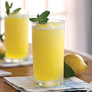 two glasses filled with lemonade sitting on top of a table