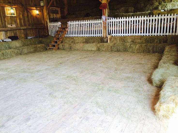 an indoor barn with hay bales and stairs