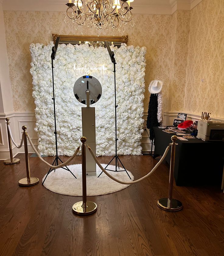 a room with white flowers on the wall and two microphones in front of it