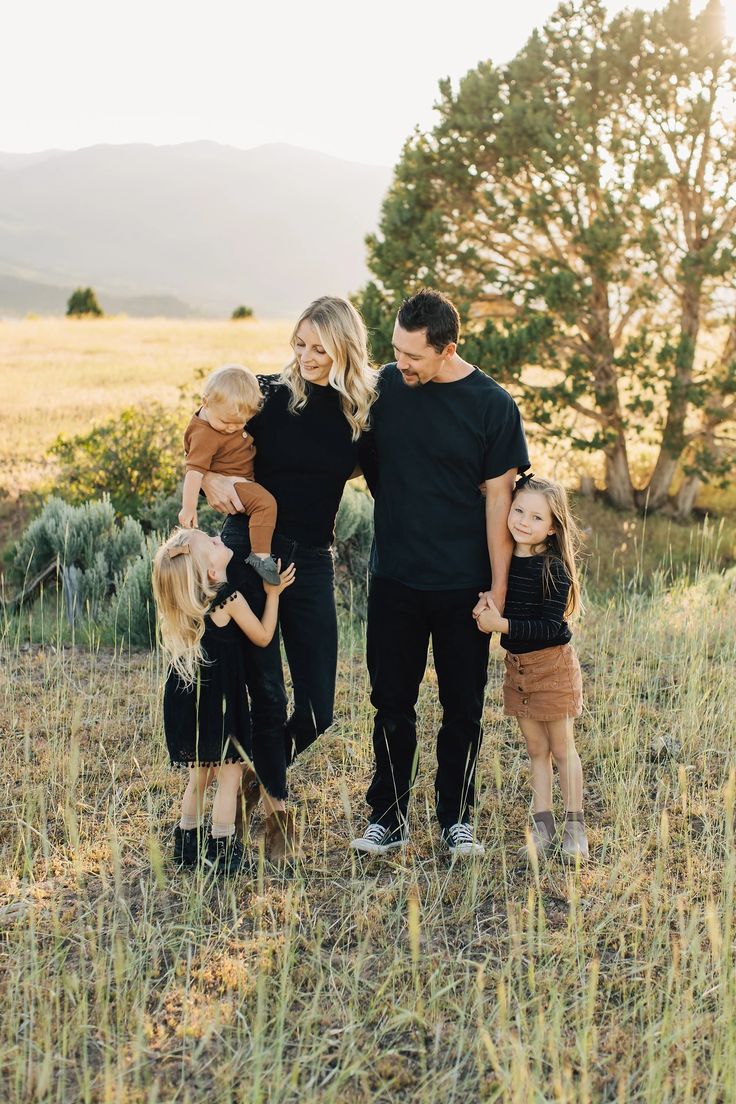 a family standing in a field holding hands