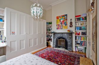 a bedroom with a bed, fireplace and bookshelf