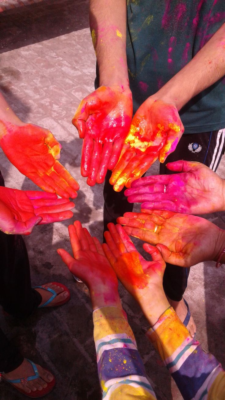 several people with their hands covered in colored powder and holding each other's hands