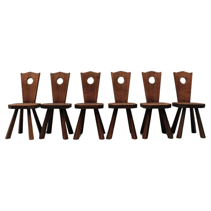 four wooden chairs sitting next to each other