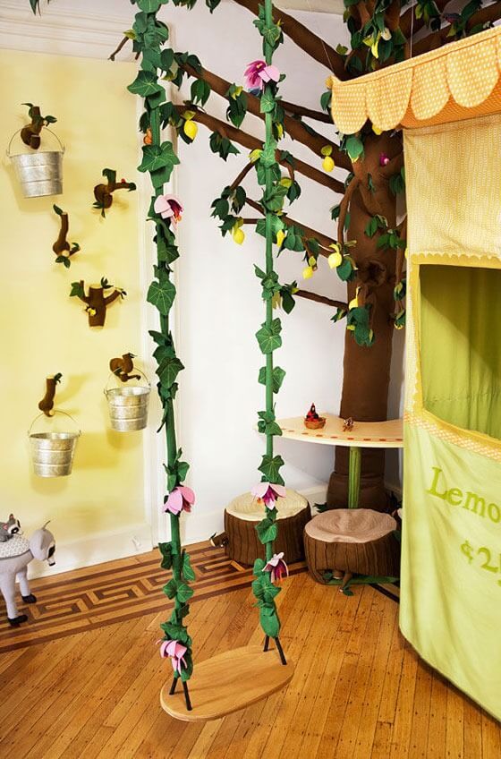 a room with wooden floors and green curtains on the ceiling, decorated with pink flowers