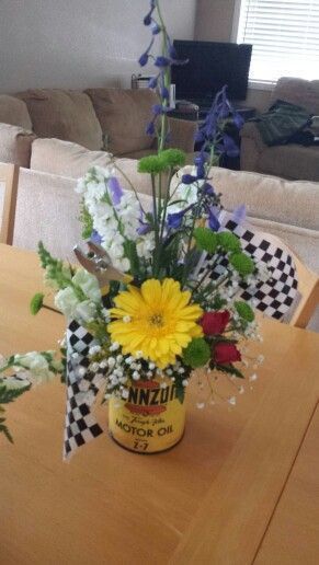 a vase filled with flowers sitting on top of a wooden table next to a couch