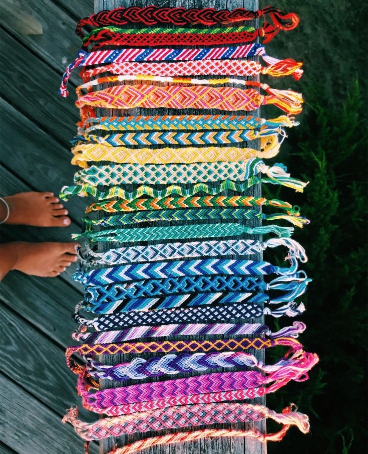 a person standing next to a pile of bracelets