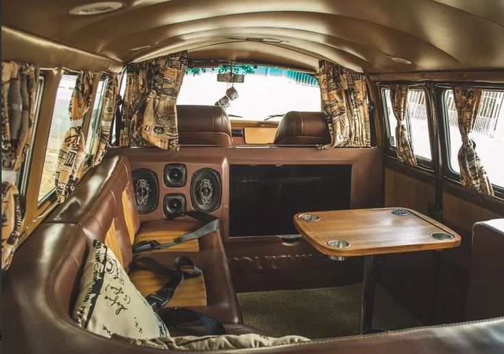 the interior of an old fashioned vehicle with wood trim and leather upholstered seats