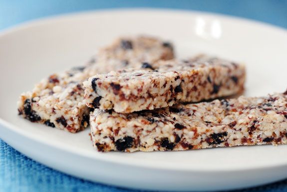 three granola bars on a white plate with blue table cloth in the back ground