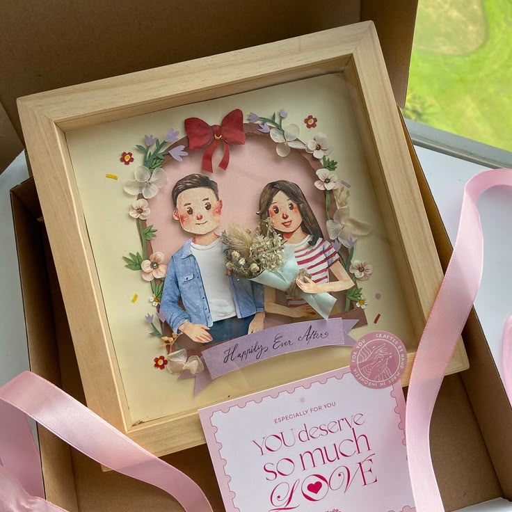 a wedding card in a box with pink ribbon on the bottom and an image of a bride and groom