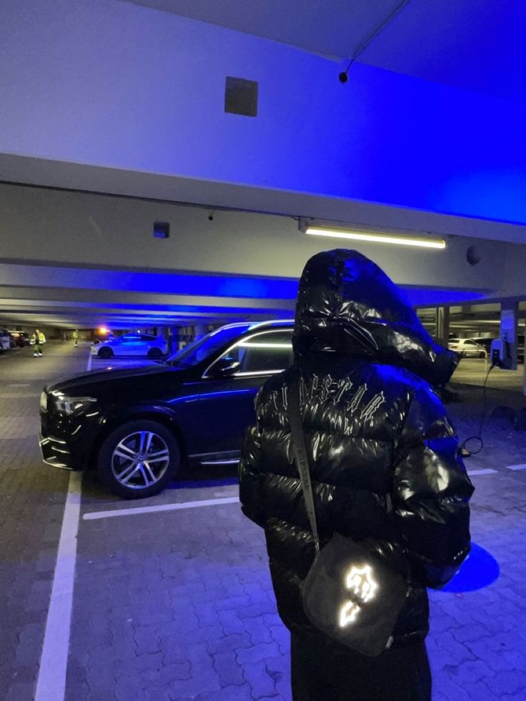 a person in a black jacket and some cars