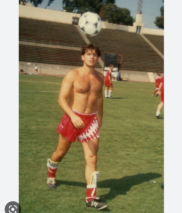 a shirtless man with no shirt is playing soccer on the field - stock image