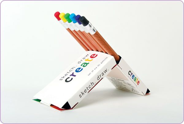 several colored pencils in a box on a white background