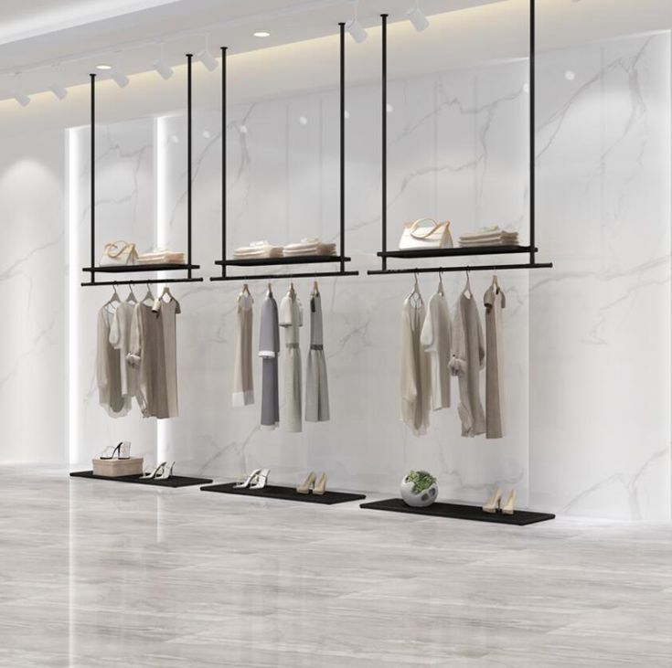 an empty clothing store with clothes hanging on the racks and shoes in the foreground