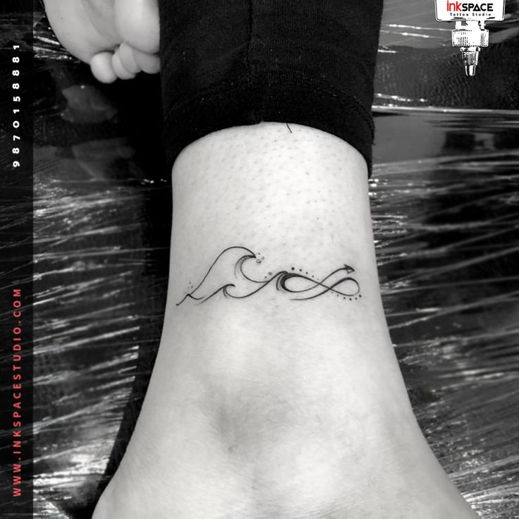 a woman's foot with a small wave tattoo on the left side of her leg