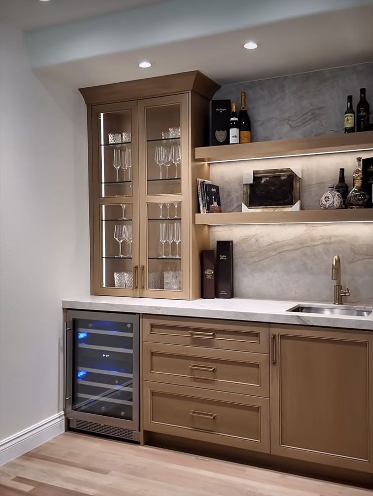 a kitchen with wooden cabinets and wine glasses on the counter top, including an oven